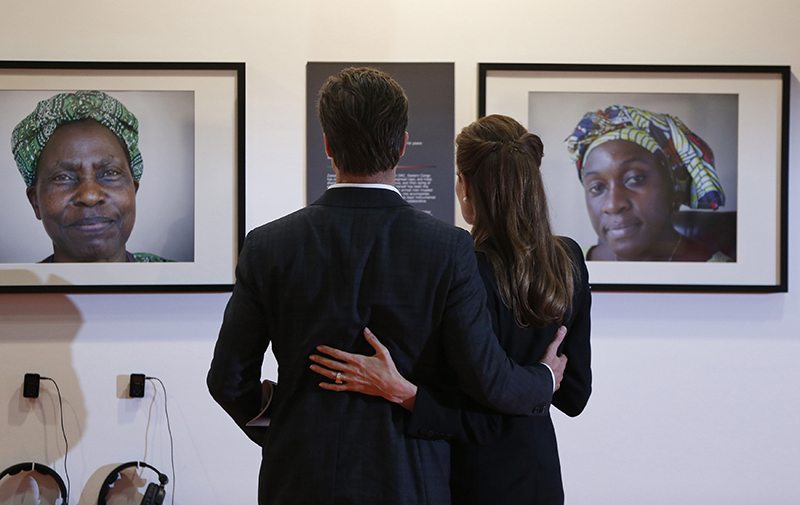 Actress and Special Envoy of the United Nations High Commissioner for Refugees, Angelina Jolie, and her partner actor Brad Pitt, look at photographs of victims of violence at the 'End Sexual Violence in Conflict' summit in London