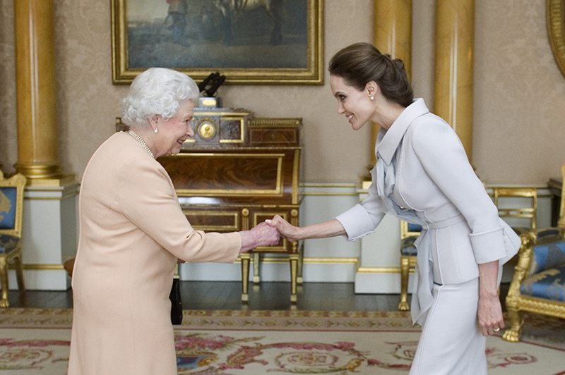 Actress Angelina Jolie is greeted by Britain's Queen Elizabeth before being presented with the Insignia of an Honorary Dame Grand Cross of the Most Distinguished Order of St Michael and St George in London