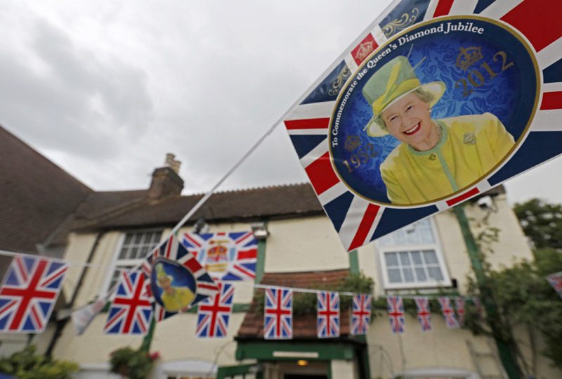 Images of Britain's Queen Elizabeth and Union flag bunting hangs across The Jubilee pub ahead of the Queen's diamond jubilee celebrations in Sunbury-on-Thames in south west London. REUTERS/Luke MacGregor