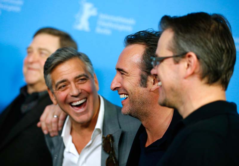 Actor Dujardin laughs as director and actor Clooney jokes with cast members Goodman and Damon during a photocall to promote the movie "The Monuments Men" during the 64th Berlinale International Film Festival in Berlin 