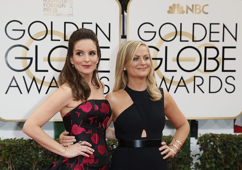 Actresses Tina Fey (L) and Amy Poehler arrive at the 71st annual Golden Globe Awards i