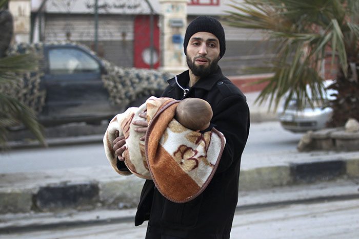 A man carries a child as he flees the last rebel-held areas of Aleppo. Picture: Reuters