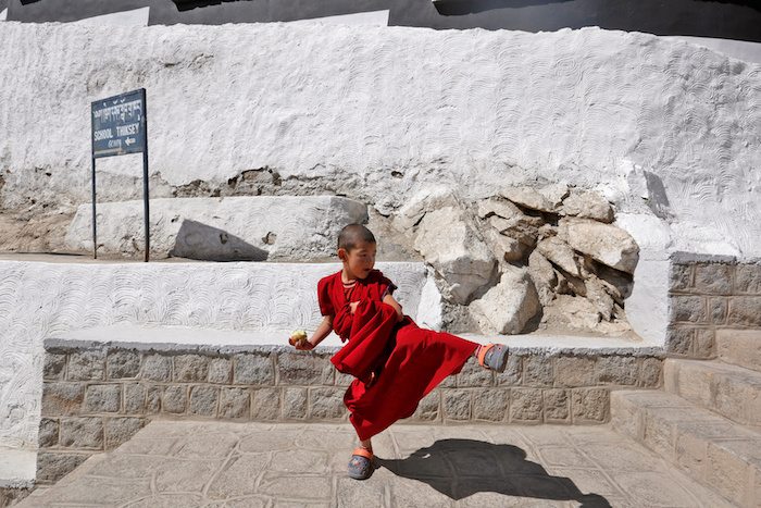 A young monk plays during a break from his studies inside Thiksey Monastery in Ladakh, India September 26, 2016. REUTERS/Cathal McNaughton   