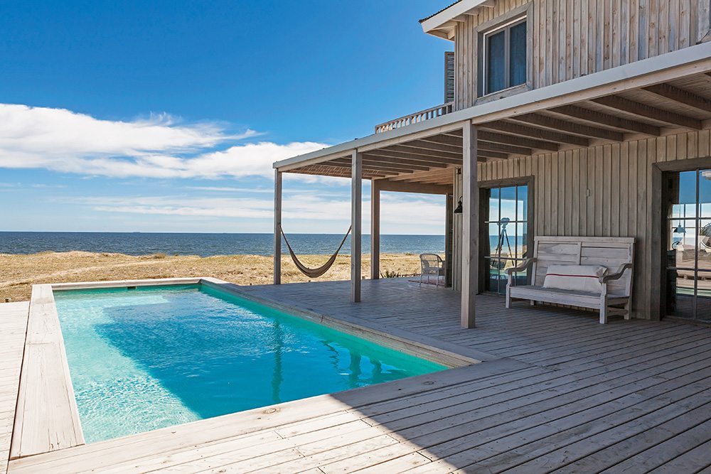 The pool surround extends slightly beyond the deck perimeter, creating the impression that it stretches out to sea.
