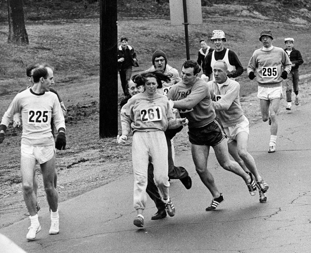 BOSTON, MA - APRIL 19: Kathrine Switzer, of Syracuse, N.Y., center, was spotted early in the Boston Marathon by Jock Semple, center right, who tried to rip the number off her shirt and remove her from the race. Switzer's friends intervened, allowing her to make her getaway to become the first woman to "officially" run the Boston Marathon on April 19, 1967. (Paul Connell/The Boston Globe via Getty Images)