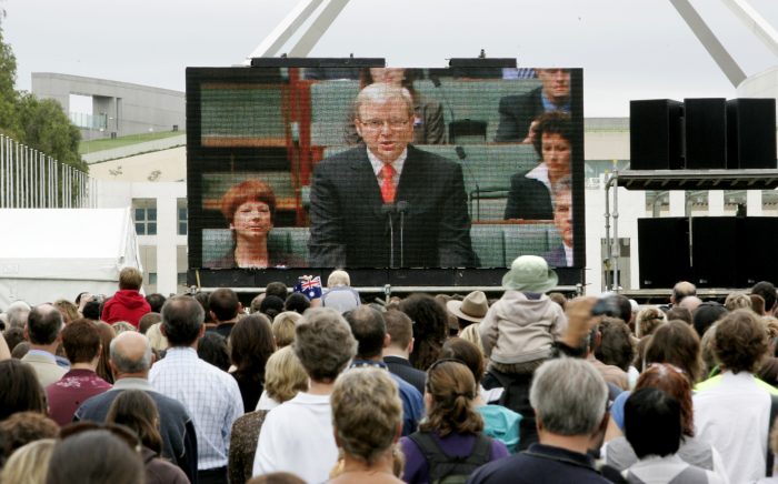 Australians gather to watch Prime Minister Kevin Rudd apologise to Aboriginal Australians on a big screen outside Parliament House in Canberra February 13, 2008.  REUTERS/Mick Tsikas     