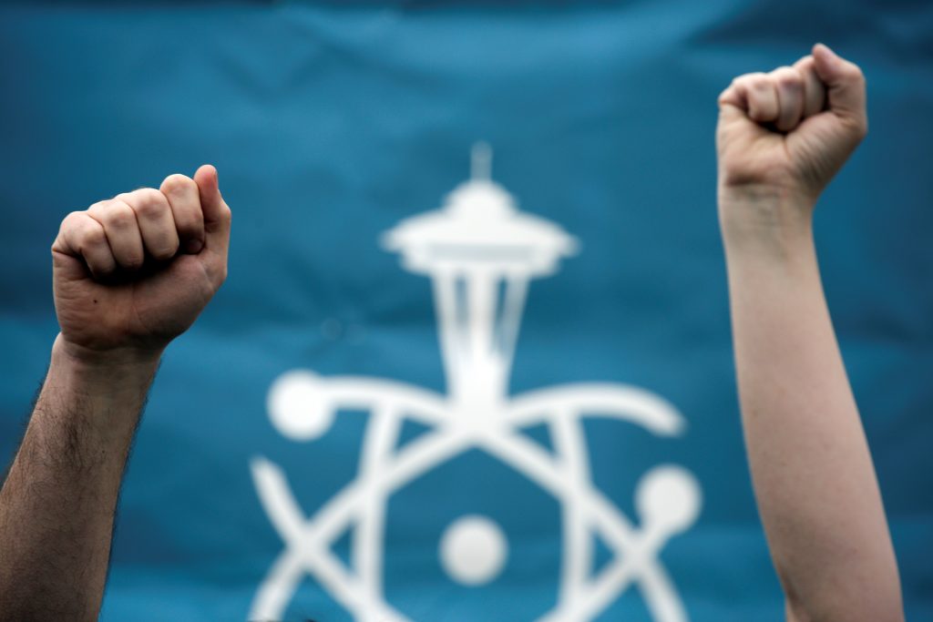 Volunteers hold their fists in the air during the March For Science in Seattle, Washington, U.S. April 22, 2017.  REUTERS/David Ryder - RTS13GR5