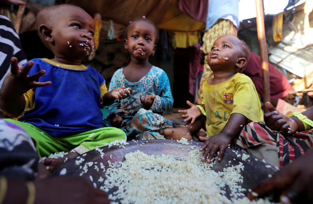 Internally displaced Somali children eat boiled rice outside their family's makeshift shelter at the Al-cadaala camp in Somalia's capital Mogadishu REUTERS/Feisal Omar  