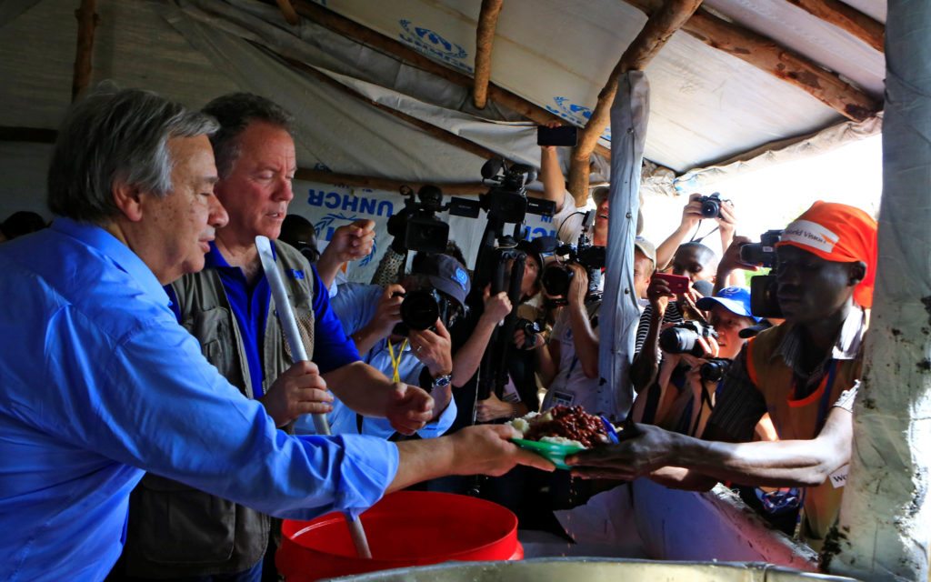 UN Secretary General Antonio Guterres (L) serves a warm meal to South Sudanese refugees who fled civil war and arrived at Imvepi settlement camp in northern Uganda June 22, 2017. REUTERS/James Akena 