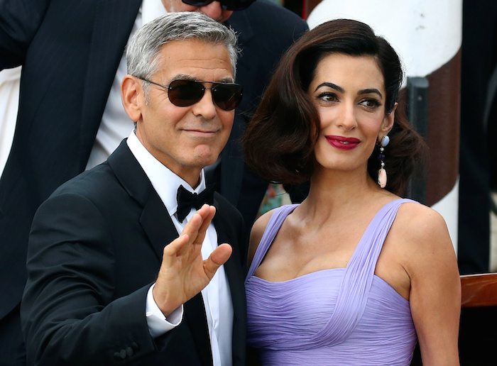 Actor and director George Clooney waves next to his wife Amal as they leave the hotel before the red carpet for the movie Suburbicon at the 74th Venice Film Festival 