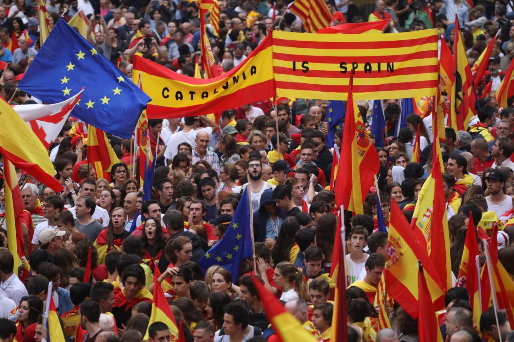 People wave Spanish, Catalan and European Union flags during a demonstration in favour of a unified Spain a day before the banned October 1 independence referendum, in Barcelona, Spain.