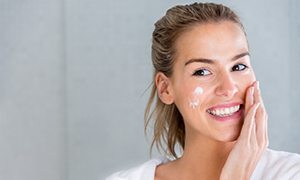 Beauty portrait of a woman using moisturizing cream