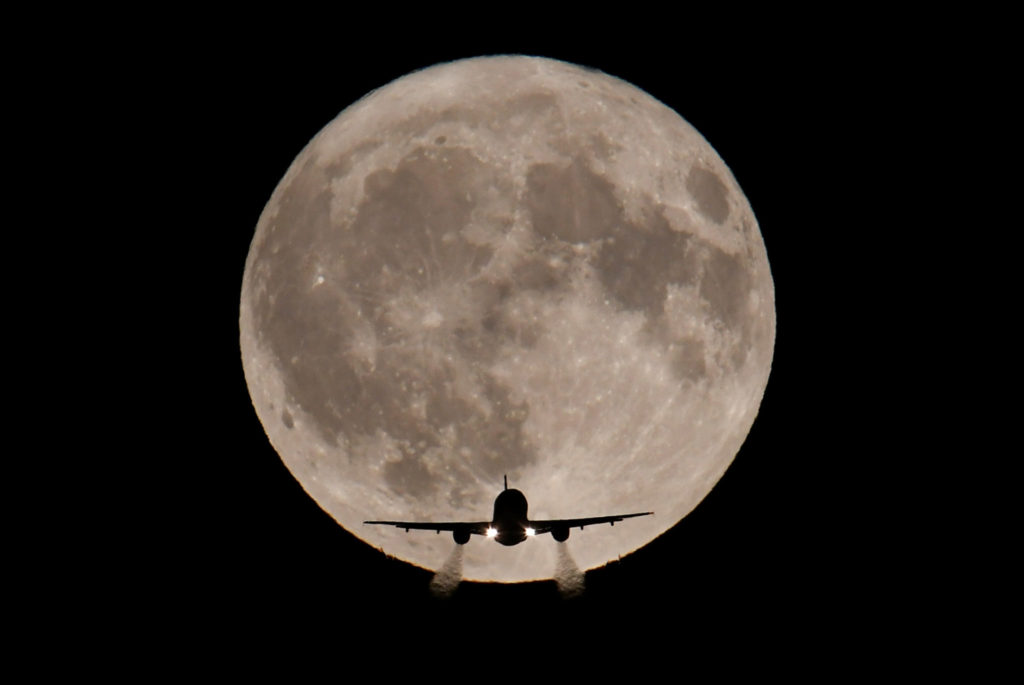A full moon behind a plane