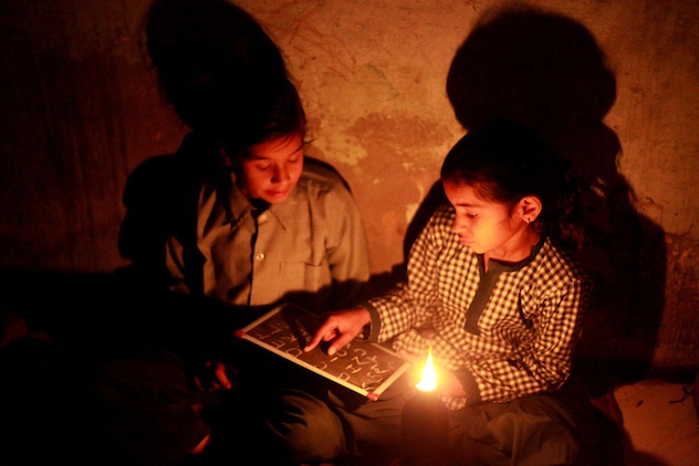 poor little girls studying at home with Diya light, A small cup-shaped oil lamp made of baked clay is called diya in rural India.