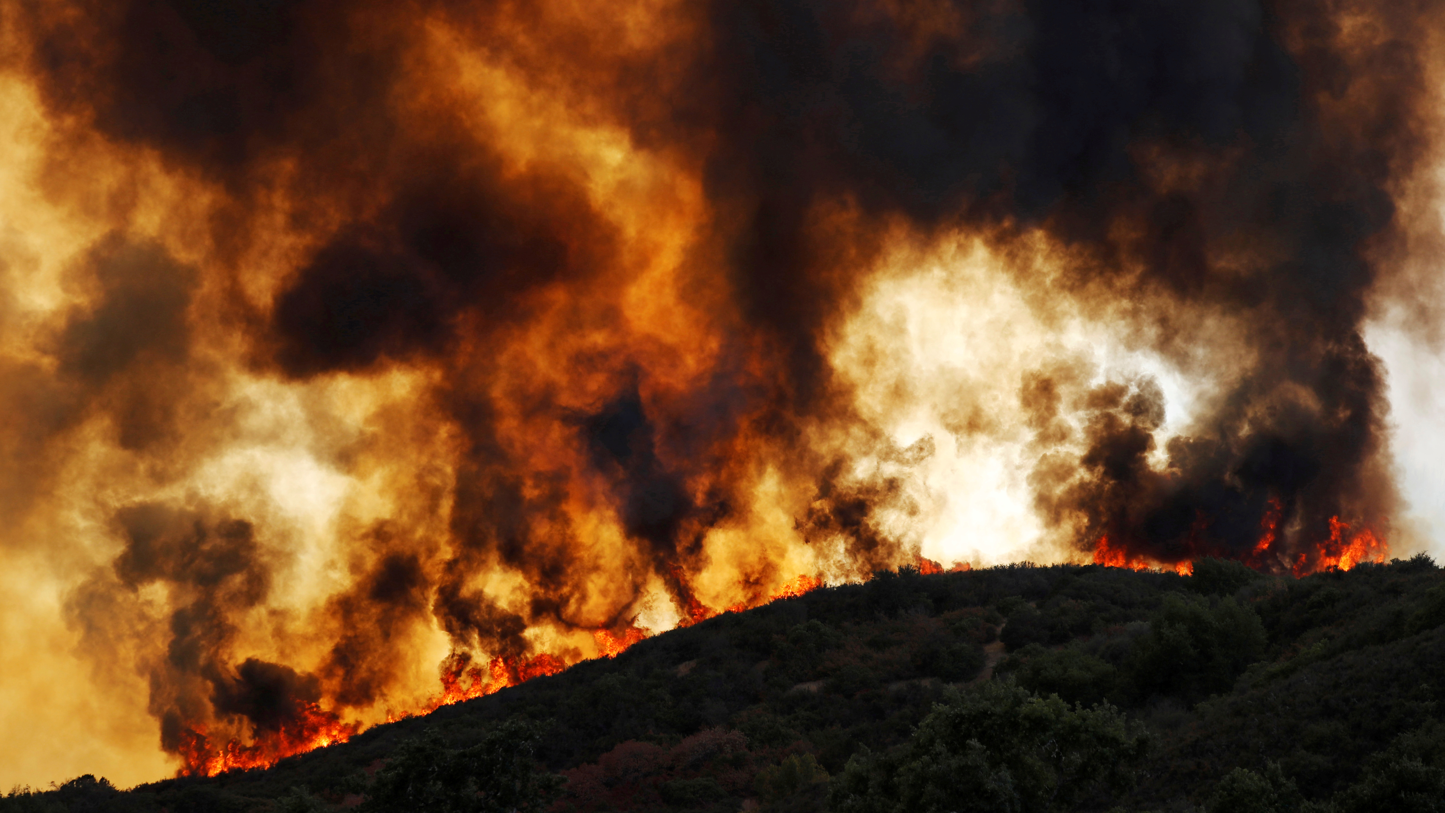 Wind-driven flames roll over a hill towards homes during the River Fire (Mendocino Complex) near Lakeport, California, U.S. August 2, 2018.  REUTERS/Fred Greaves      TPX IMAGES OF THE DAY - RC11C39831D0