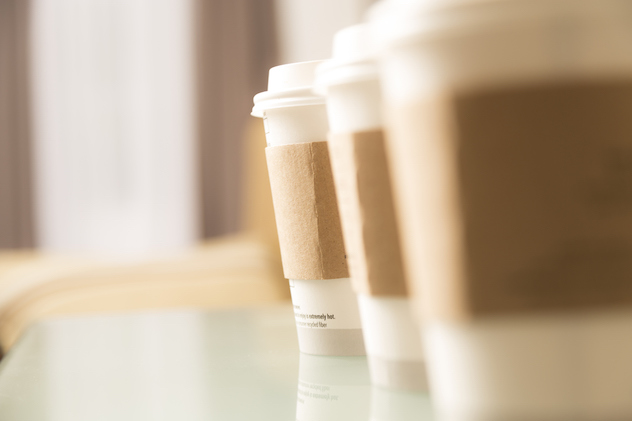Three cups of coffee sitting on a glass top office table or cafe.  Catering for office meeting or drinks in coffee shop.