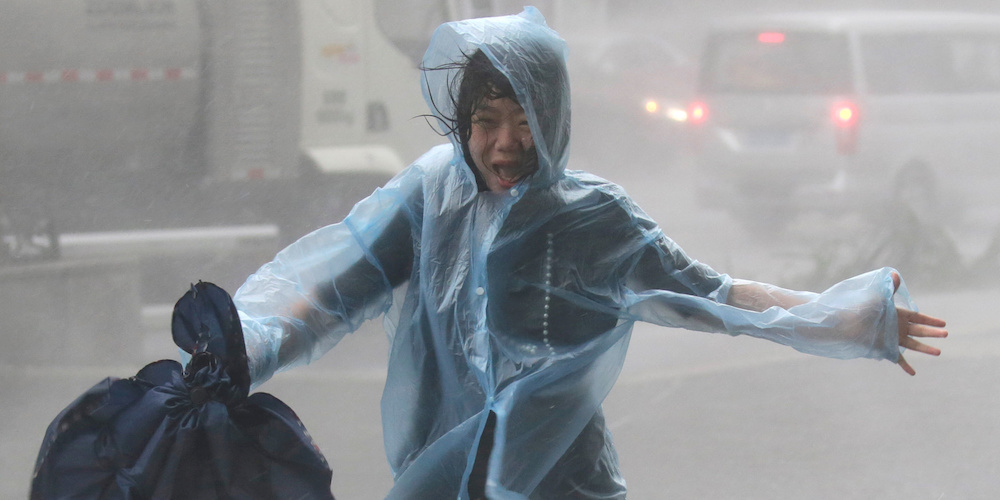 A woman runs in the rainstorm as Typhoon Mangkhut approaches, in Shenzhen, China September 16, 2018. REUTERS/Jason Lee  TPX IMAGES OF THE DAY - RC1D37D20F50
