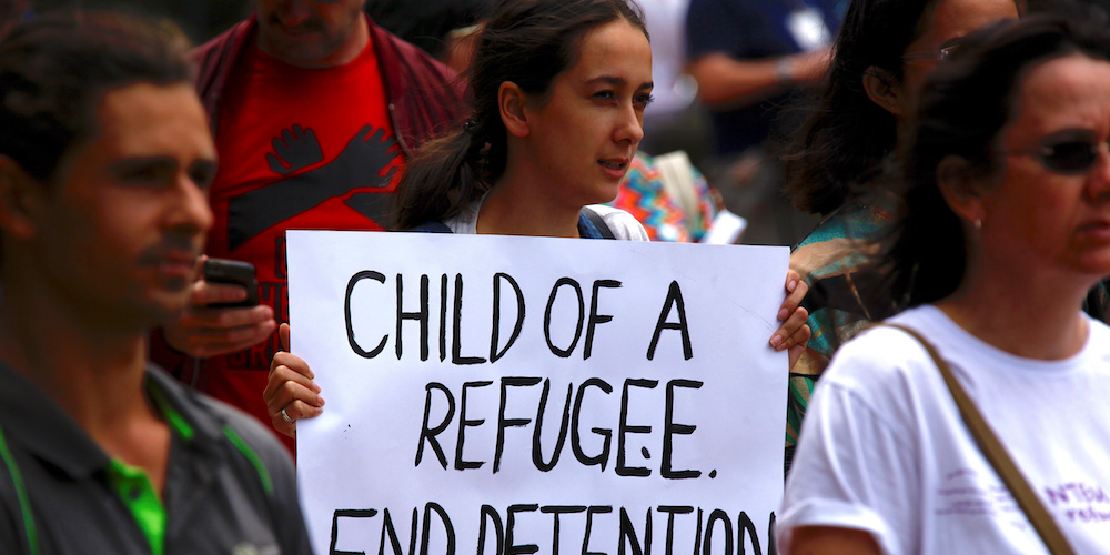 Refugee advocates hold placards as they participate in a protest in Sydney, Australia, against the treatment of asylum-seekers at Australia-run detention centres located at Nauru and Manus Island.    REUTERS/David Gray