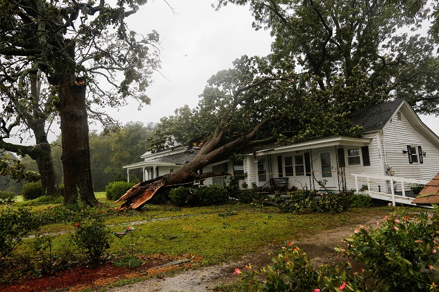 A downed tree rests on a house during the passing of Hurricane Florence in the town of Wilson, North Carolina, U.S. September 14, 2018. REUTERS/Eduardo Munoz - RC1178C7F670