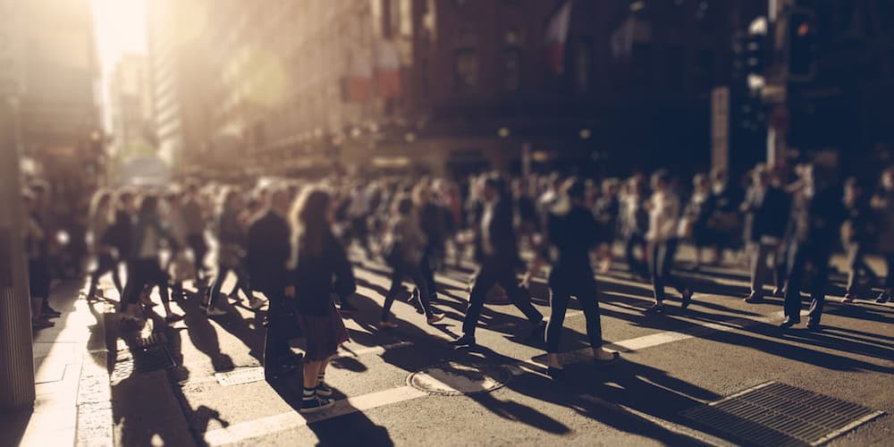 Crowd of people walking over the crosswalk at sunset. Sydney, Australia