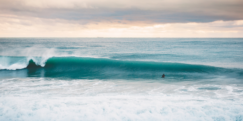 A Perfect big breaking Ocean barrel wave and surfer