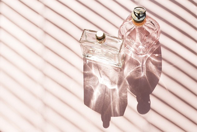 Perfume bottles on a bright light with the shadows