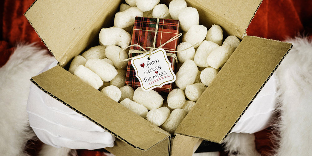 Santa with package to mail. Tag on gift reads: Love from across the Miles**Fine grain has been added to this image