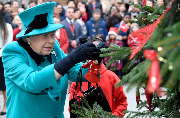 Britain's Queen Elizabeth and Shylah Gordon, aged 8, attach a bauble to a Christmas tree during a visit to children's charity Coram in London, Britain, December 5, 2018. REUTERS/Toby Melville     TPX IMAGES OF THE DAY - RC1331052820