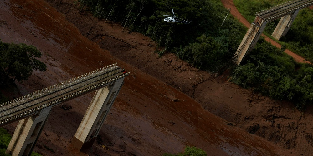 A helicopter flies over a dam owned by Brazilian miner Vale SA that burst, in Brumadinho, Brazil January 25, 2019. REUTERS/Washington Alves - RC1E3443D030