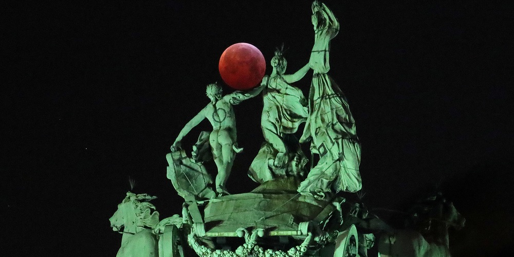 The moon is seen beside a quadriga on the top of the Cinquantenaire arch during a total lunar eclipse, known as the "Super Blood Wolf Moon", in Brussels, Belgium January 21, 2019. REUTERS/Yves Herman     TPX IMAGES OF THE DAY - RC1C7A25B790
