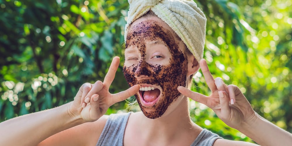 Face Skin Scrub. Portrait Of Sexy Smiling Female Model Applying Natural Coffee Mask, Face Scrub On Facial Skin. Closeup Of Beautiful Happy Woman With Face Covered With Beauty Product. High Resolution. (Face Skin Scrub. Portrait Of Sexy Smiling Female