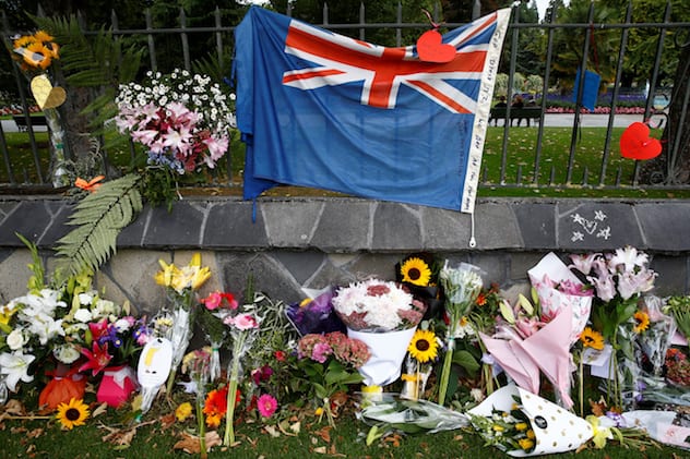 Flowers and a New Zealand national flag are seen at a memorial as tributes to victims of the mosque attacks near Linwood mosque in Christchurch.  Photo Credit: REUTERS/Edgar Su