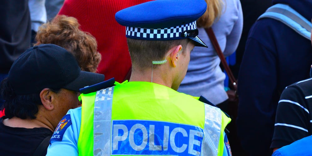Auckland, New Zealand - November 4, 2015: A New Zealand police officer walks in a crowd of people. With over 11, 000 staff New Zealand police is the largest law enforcement agency in New Zealand