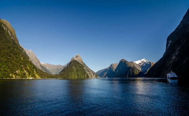 Cruise ships tend to be dwarfed by the towering peaks of Milford Sound, one of the Seven Natural Wonders of Oceania. ISTOCK