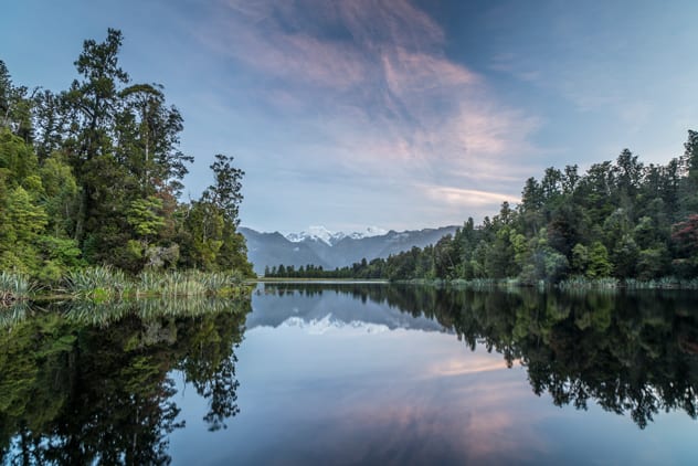 Lake Matheson is renowned for its still reflections, offering picture-perfect views back to the high alpine peaks beyond.
