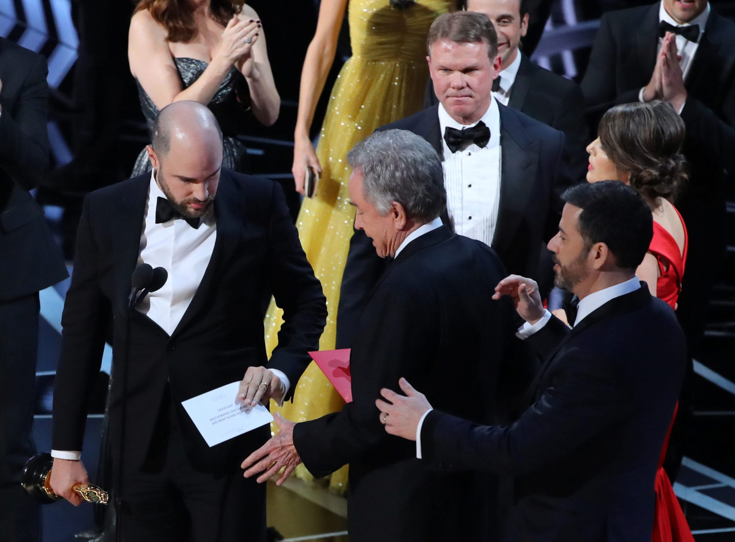 89th Academy Awards - Oscars Awards Show - Hollywood, California, U.S. - 26/02/17 - Martha Ruiz (R, in red) and Brian Cullinan (upper R) of PricewaterhouseCoopers confer on stage after the Best Picture was mistakenly awarded to "La La Land" instead of "Moonlight". Accountants PricewaterhouseCoopers, who oversee the ballots, said presenters Warren Beatty (C) and Faye Dunaway (not pictured) had mistakenly been given the wrong category envelope. At right is host Jimmy Kimmel and at left is "La La Land" producer Jordan Horowitz, holding the correct envelope for Best Picture. REUTERS/Lucy Nicholson     TPX IMAGES OF THE DAY - RC1AC0E51F10