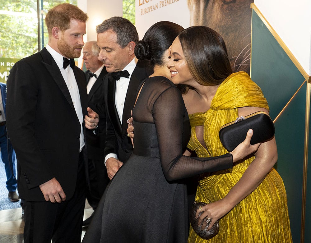 Prince Harry chats with Disney CEO Robert Iger as Meghan embraces Beyonce at the European premiere of The Lion King in London.