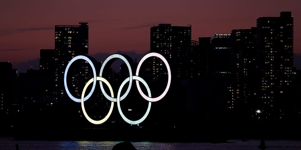 The giant Olympic rings are seen in the dusk at the waterfront area at Odaiba Marine Park in Tokyo, Japan, March 22, 2020. REUTERS/Issei Kato - RC2ZOF9J1K9L