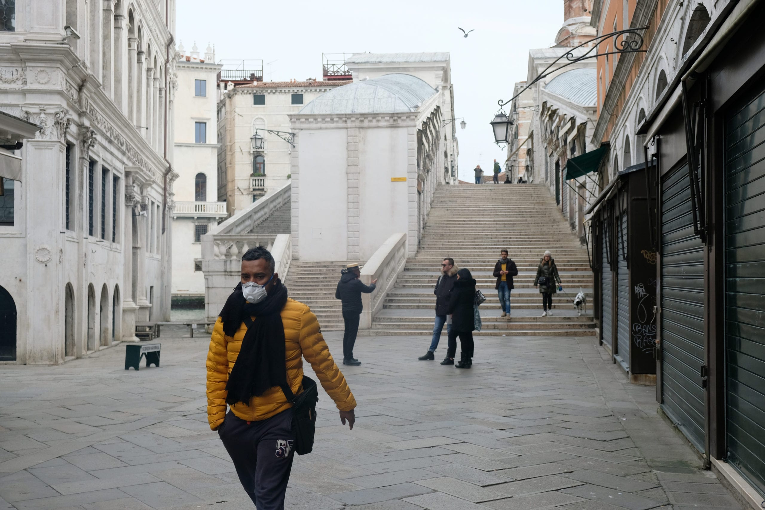 A man wearing a protective face mask walks through a street after the Italian government imposed a virtual lockdown on the north of Italy including Venice to try to contain a coronavirus outbreak, in Venice, Italy, March 9, 2020. REUTERS/Manuel Silvestri