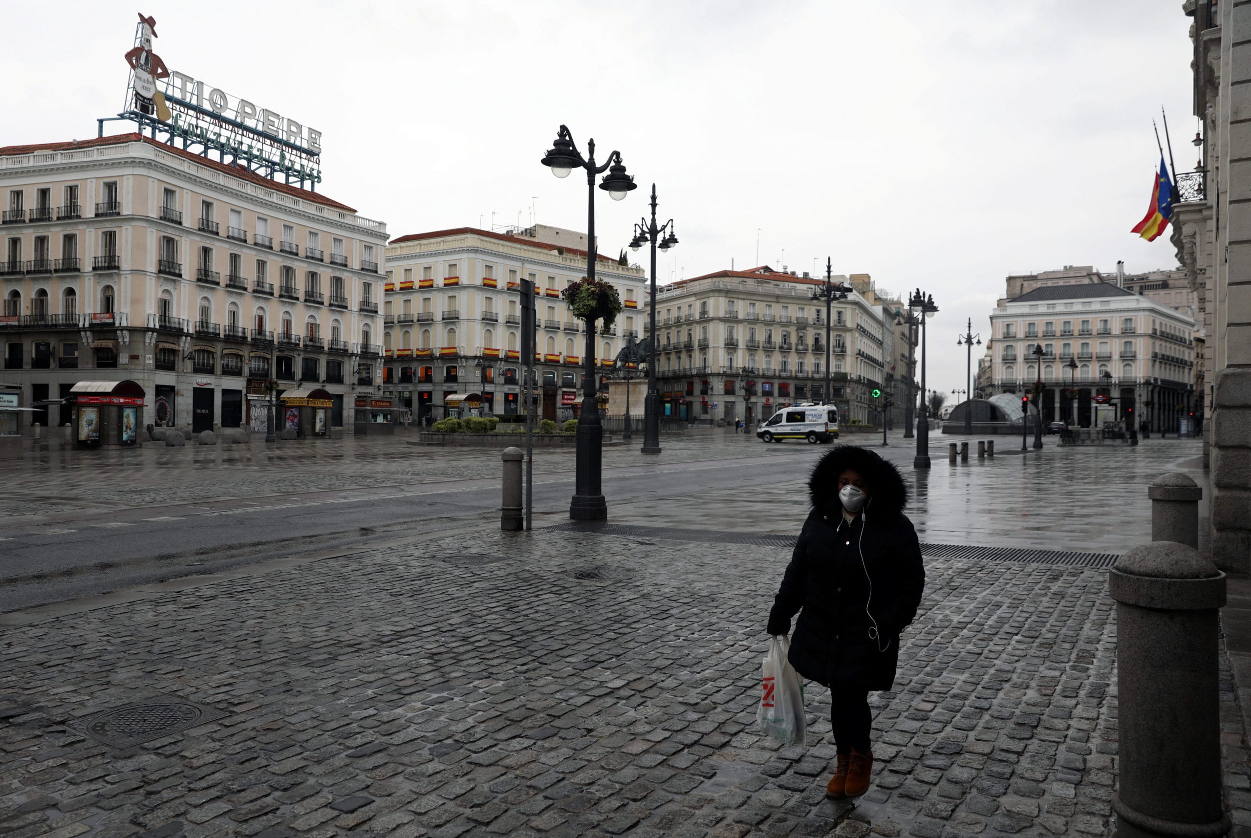 A person walks in an empty Puerta del Sol square amid the COVID-19 outbreak in Madrid, Spain. REUTERS/Sergio Perez