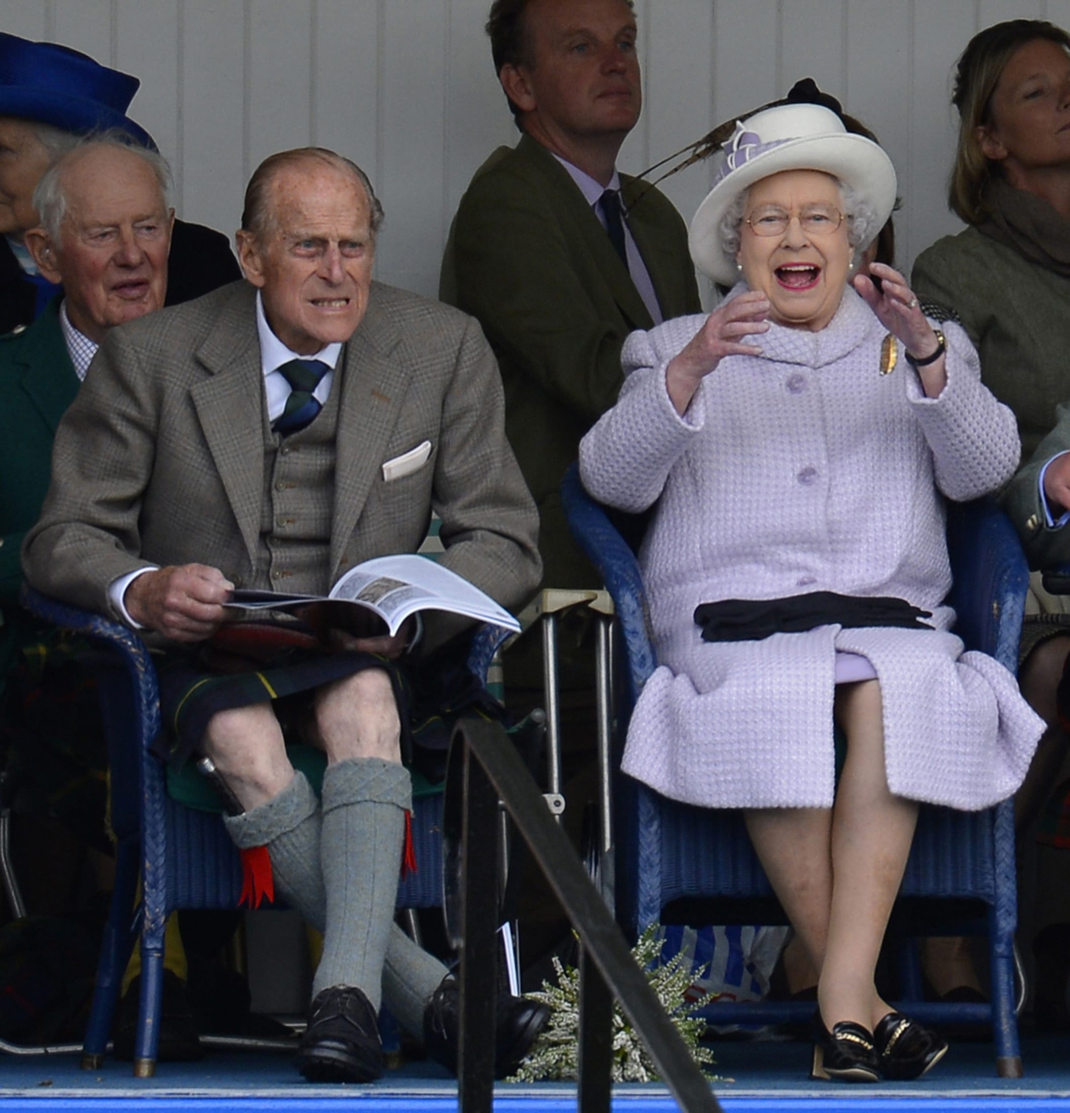 Members of Britain's royal family (front L-R) Prince Philip and Queen Elizabeth cheer as competitors participate in a sack race at the Braemar Gathering in Braemar, Scotland September 1, 2012. REUTERS