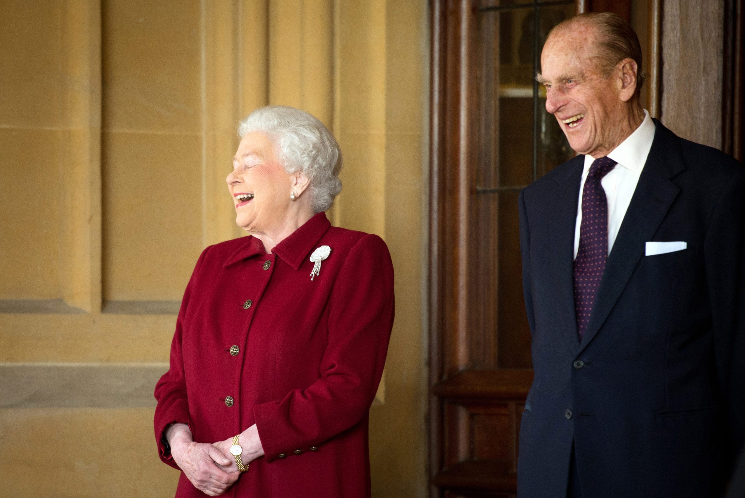 Britain's Queen Elizabeth and Prince Philip laugh after bidding farewell to the President of Ireland Michael D. Higgins and his wife Sabina at Windsor Castle in Windsor, southern England April 11, 2014.  The Irish President and his wife Sabina left Windsor at the end of a four day State Visit to Britain, during which they stayed at Windsor Castle as guests of Queen Elizabeth.  REUTERS/Leon Neal/Pool     (BRITAIN - Tags: ENTERTAINMENT SOCIETY ROYALS) - LM1EA4B125J01