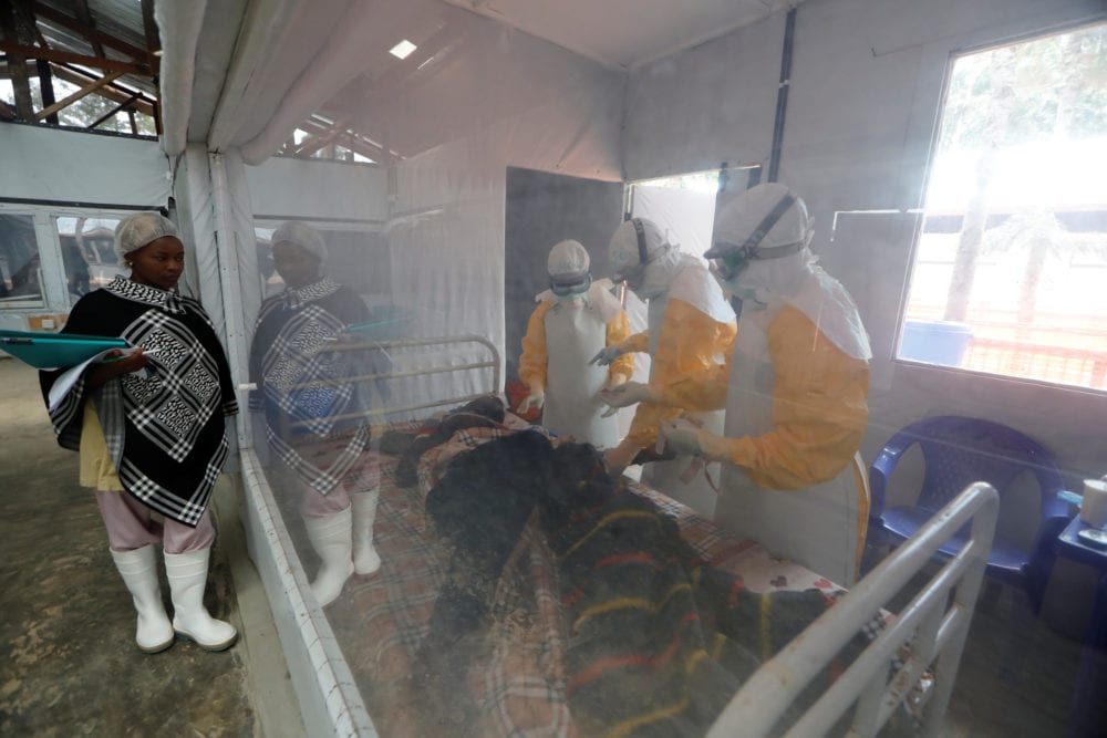 <em>Moise Vaghemi, 33, (C) an Ebola survivor who works as a nurse, cares for a patient who is suspected to be suffering from Ebola, inside the Biosecure Emergency Care Unit (CUBE) at the Ebola treatment centre in Katwa, near Butembo, in the Democratic Republic of Congo, October 3, 2019.  REUTERS/Zohra Bensemra</em>