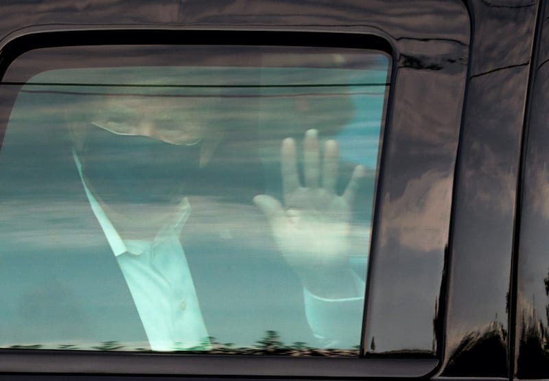 FILE PHOTO: U.S. President Donald Trump waves to supporters as he briefly rides by in the presidential motorcade in front of Walter Reed National Military Medical Center, where he is being treated for coronavirus disease (COVID-19) in Bethesda, Maryland, U.S. October 4, 2020.  REUTERS/Cheriss May/File Photo