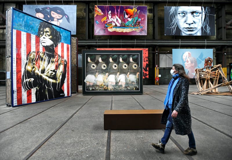 A woman wearing a mask looks at street art as she walks at the International Street Art Museum following the new social restrictions announced by the Dutch government, as the Netherlands battle to control the spread of the coronavirus disease (COVID-19), in Amsterdam, Netherlands 14 October 2020. REUTERS/Piroschka van de Wouw