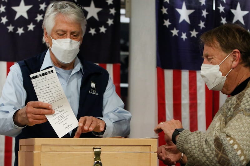 Selectman Les Otten drops a ballot in a box shortly after midnight for the U.S. presidential election at the Hale House at Balsams Hotel in the hamlet of Dixville Notch, New Hampshire, U.S., November 3, 2020. REUTERS/Ashley L. Conti