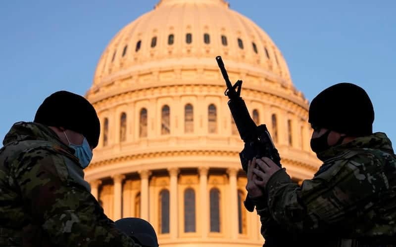 A member of the National Guard is given a weapon before Democrats begin debating one article of impeachment against U.S. President Donald Trump at the U.S. Capitol, in Washington, U.S., January 13, 2021. REUTERS/Joshua Roberts