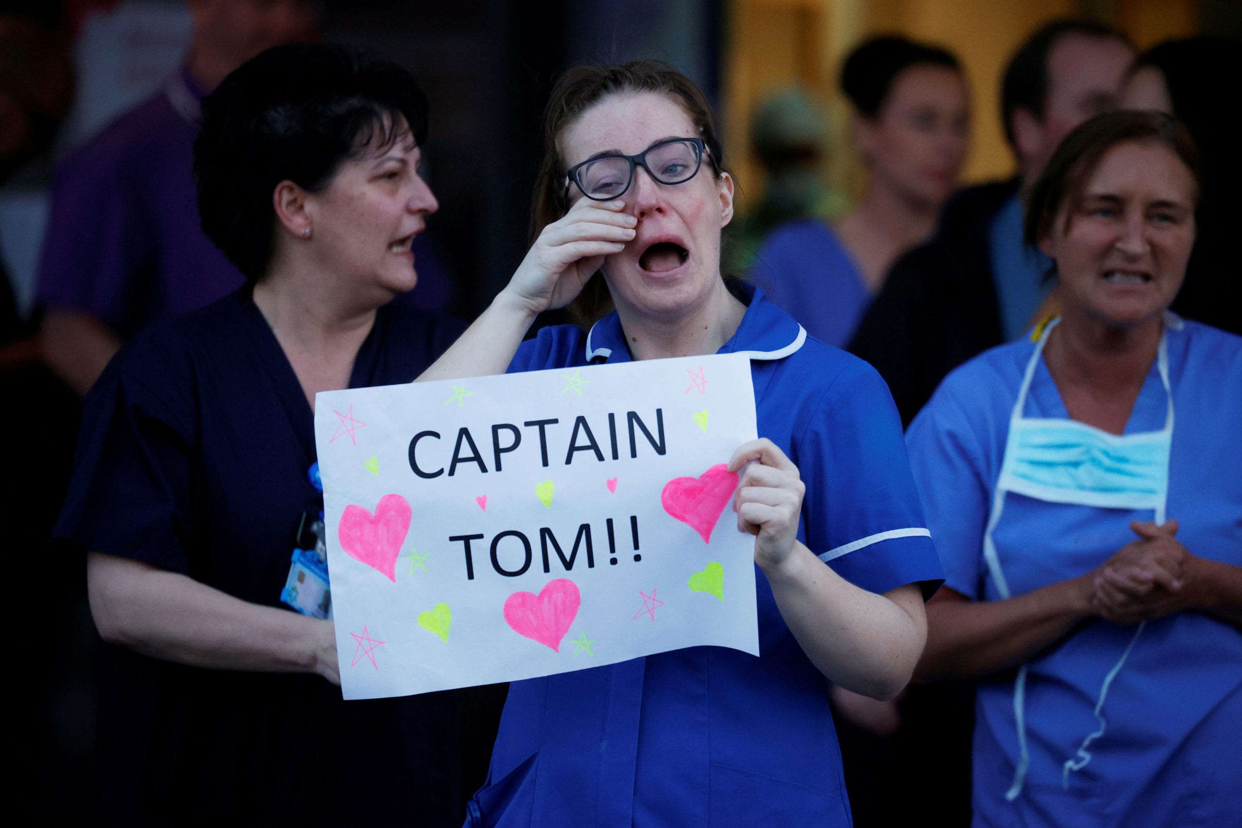 A crying NHS worker holds a message from Captain Tom outside the Aintree University Hospital during the Clap for our Carers campaign in support of the NHS as the spread of the coronavirus disease (COVID-19) continues, Liverpool, Britain, April 16, 2020. REUTERS/Phil Noble