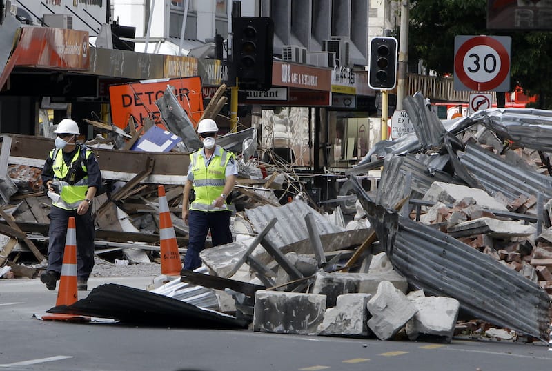 Police officers walk through rubble in central Christchurch March 2, 2011. New Zealand came to a standstill on Tuesday as people marked the moment a deadly earthquake shattered the country's second-biggest city Christchurch a week ago, and the number of confirmed dead rose by one to 155. REUTERS/Mark Baker/Pool