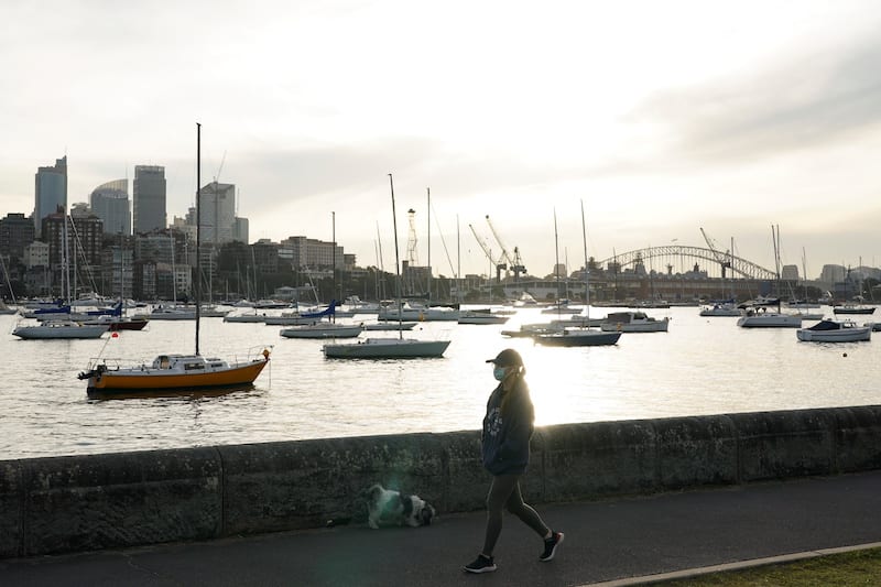 A woman wearing a protective face mask walks along a waterfront path during a lockdown to curb the spread of a coronavirus disease (COVID-19) outbreak in Sydney, Australia, July 8, 2021.  REUTERS/Loren Elliott